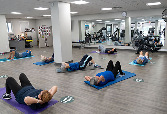 Seniors preforming sit-ups in a group fitness class.