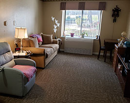 Interior of room with an emergency system on the wall above a couch and side table.