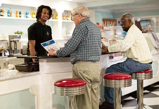 Two senior male friends placing orders at Scoops.