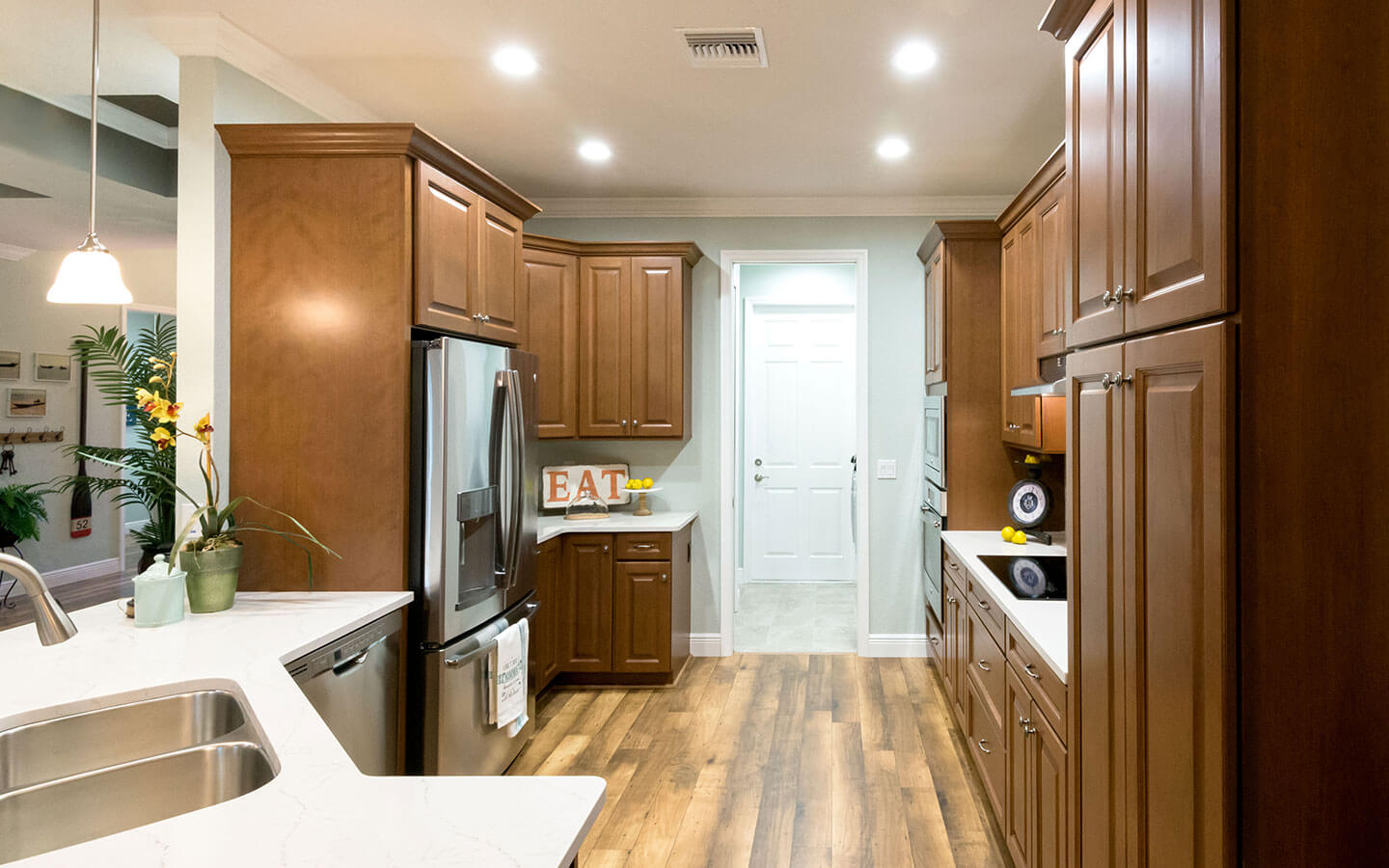 Large kitchen with dark wood cabinets, stove, oven and microwave.