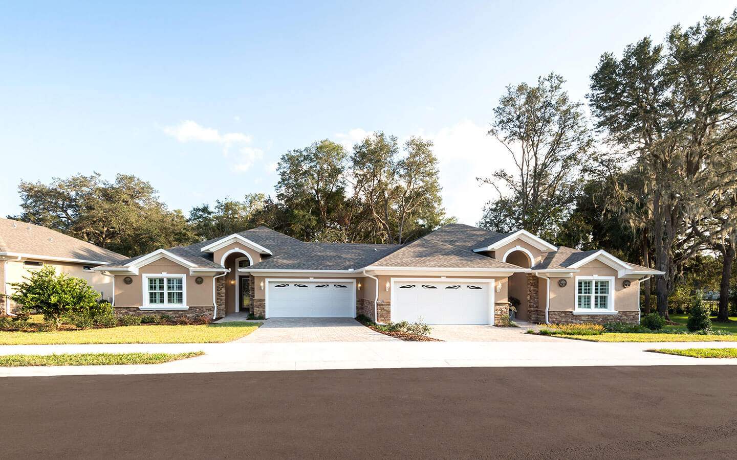 Exterior duplex with tan paint and brown bricked fronts.