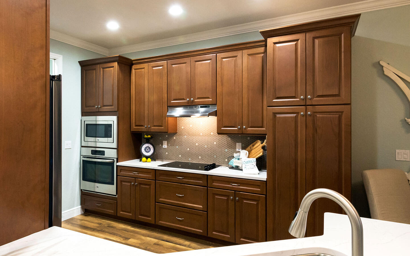 Large kitchen with dark wood cabinets, stove, oven and microwave.