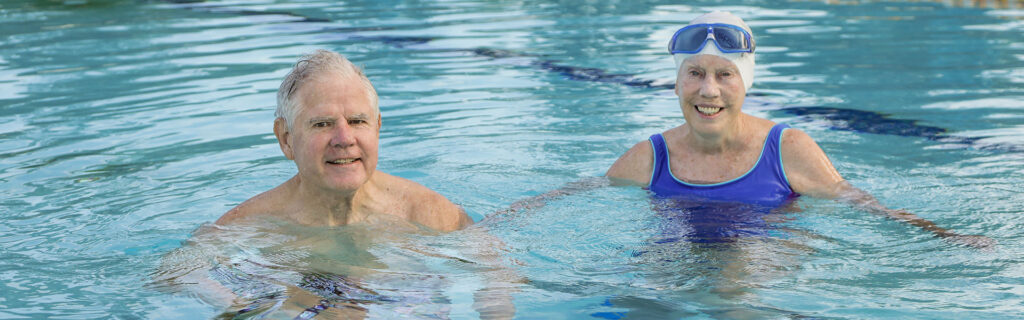 Couple swimming in pool.
