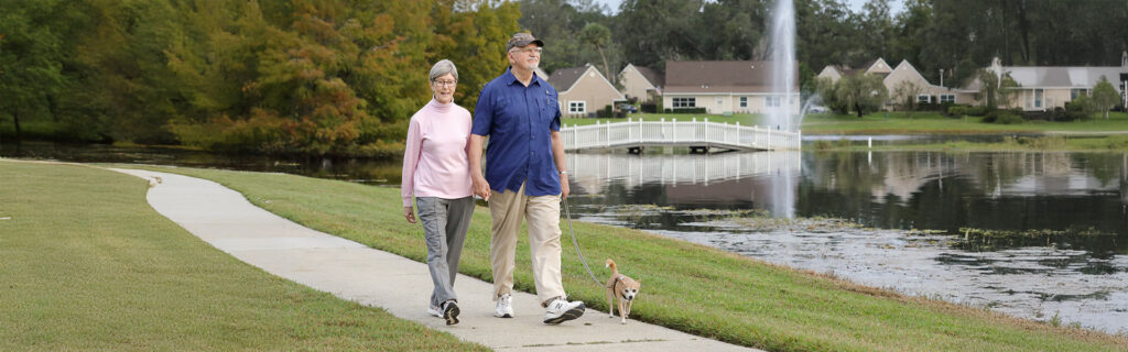 Couple walking a small dog.